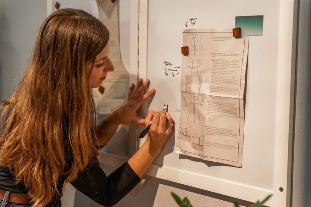 Delve into the art of fashion as a girl in black long sleeves designs dress patterns on a white